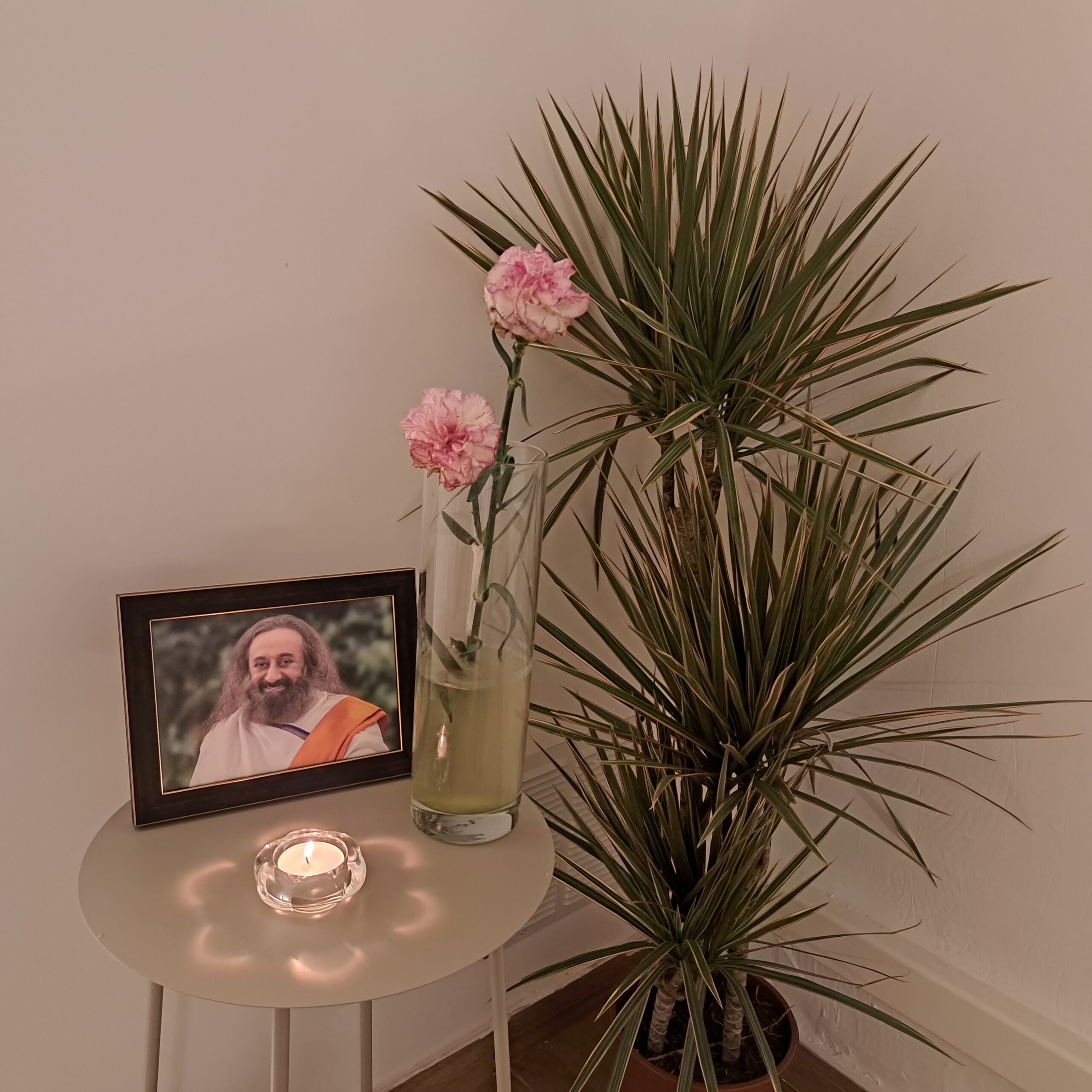 Mesa de meditación con flores, vela y foto enmarcada