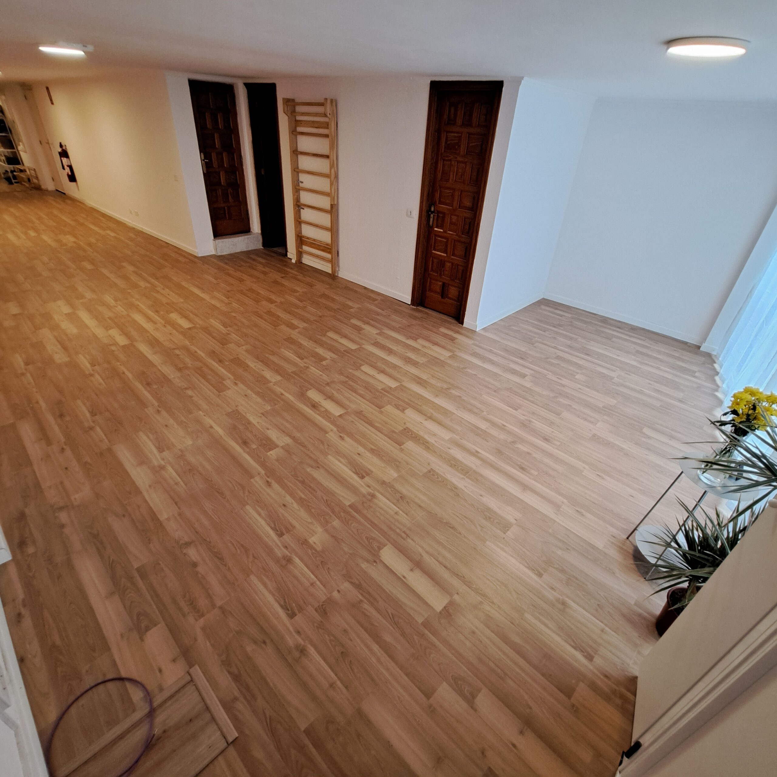 Sala espaciosa de Ocean and Om con suelo de madera, flores, plantas y espaldera