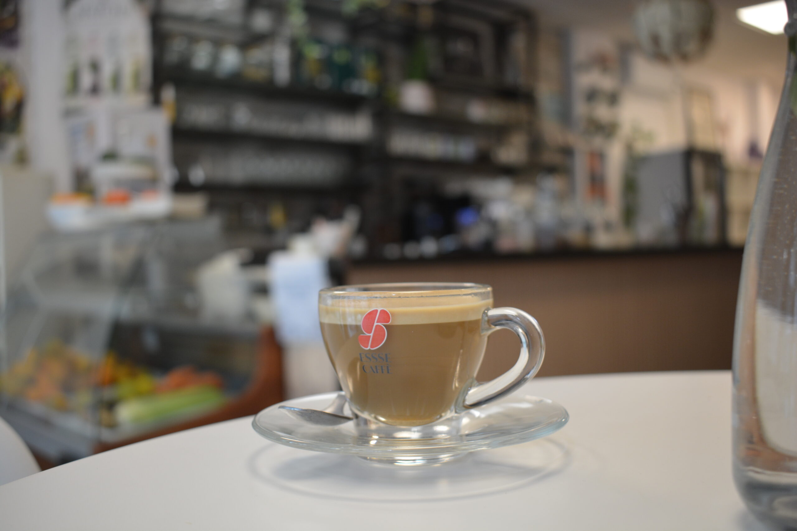 Taza de café sobre una mesa blanca en la cafetería de Ocean and Om