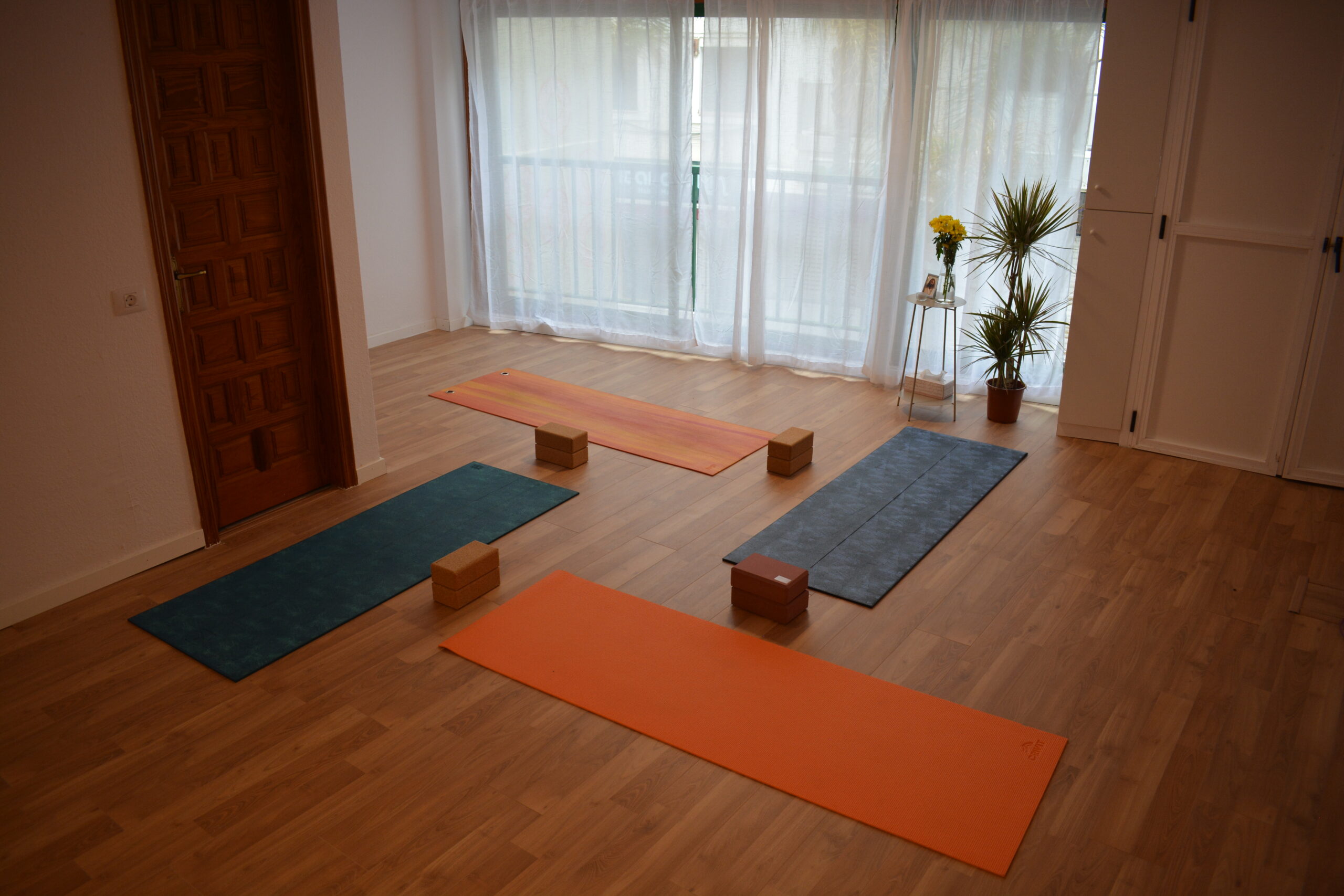 Estudio de yoga luminoso con cuatro esterillas y bloques