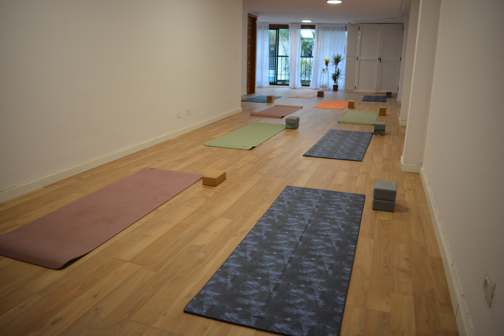 Estudio de yoga lleno de luz con esterillas y bloques