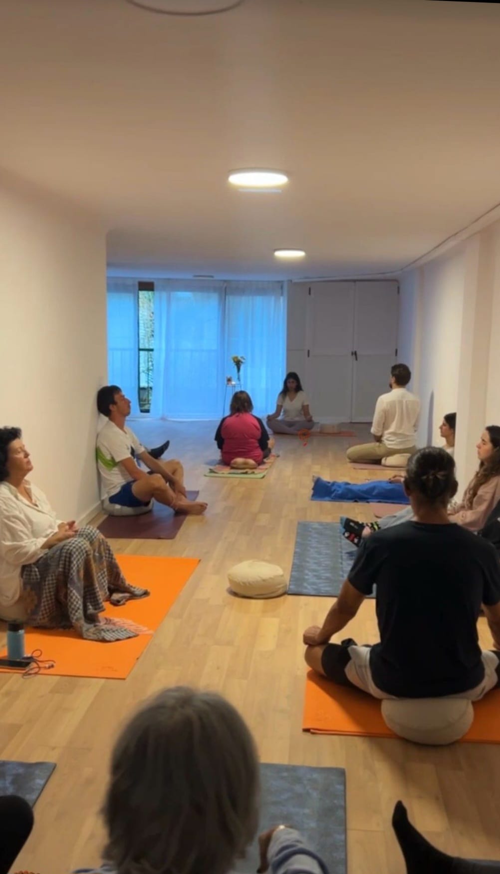 Grupo practicando meditacion guiada en la sala de Ocean and Om